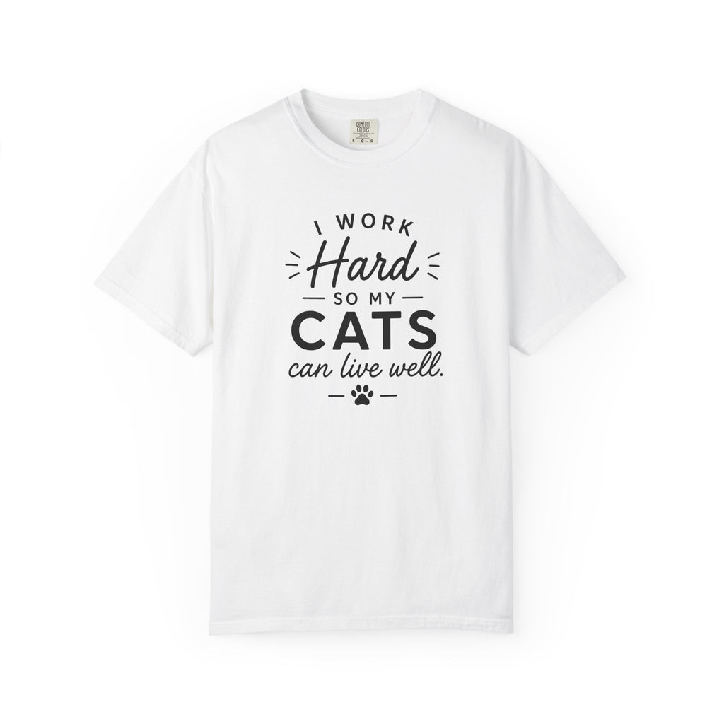 A white short-sleeve crewneck t-shirt with a black graphic text print that reads 'I WORK Hard SO MY CATS can live well.' with a small paw print underneath, displayed on a clean white background.