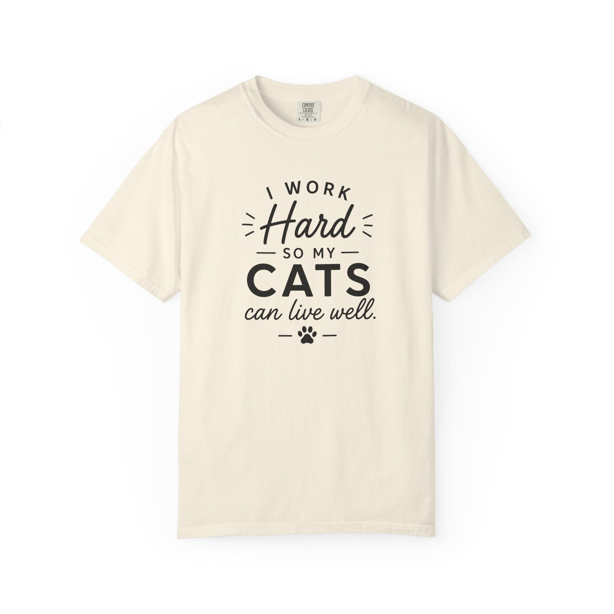 An off-white crewneck t-shirt with a black graphic text print that reads 'I WORK Hard SO MY CATS can live well.' with a paw print accent, displayed on a clean white background.