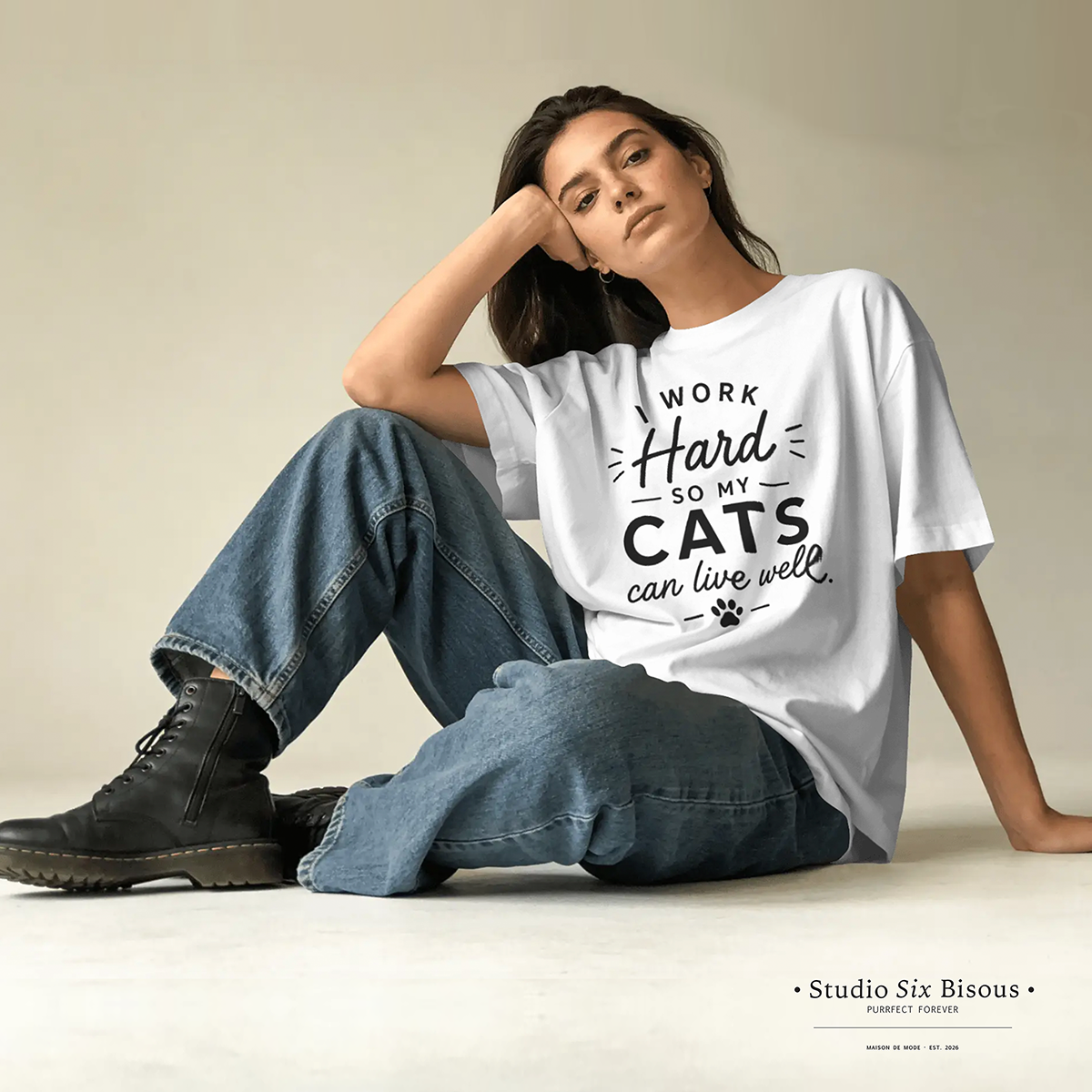 Woman wearing a white t-shirt with text sitting on the floor.