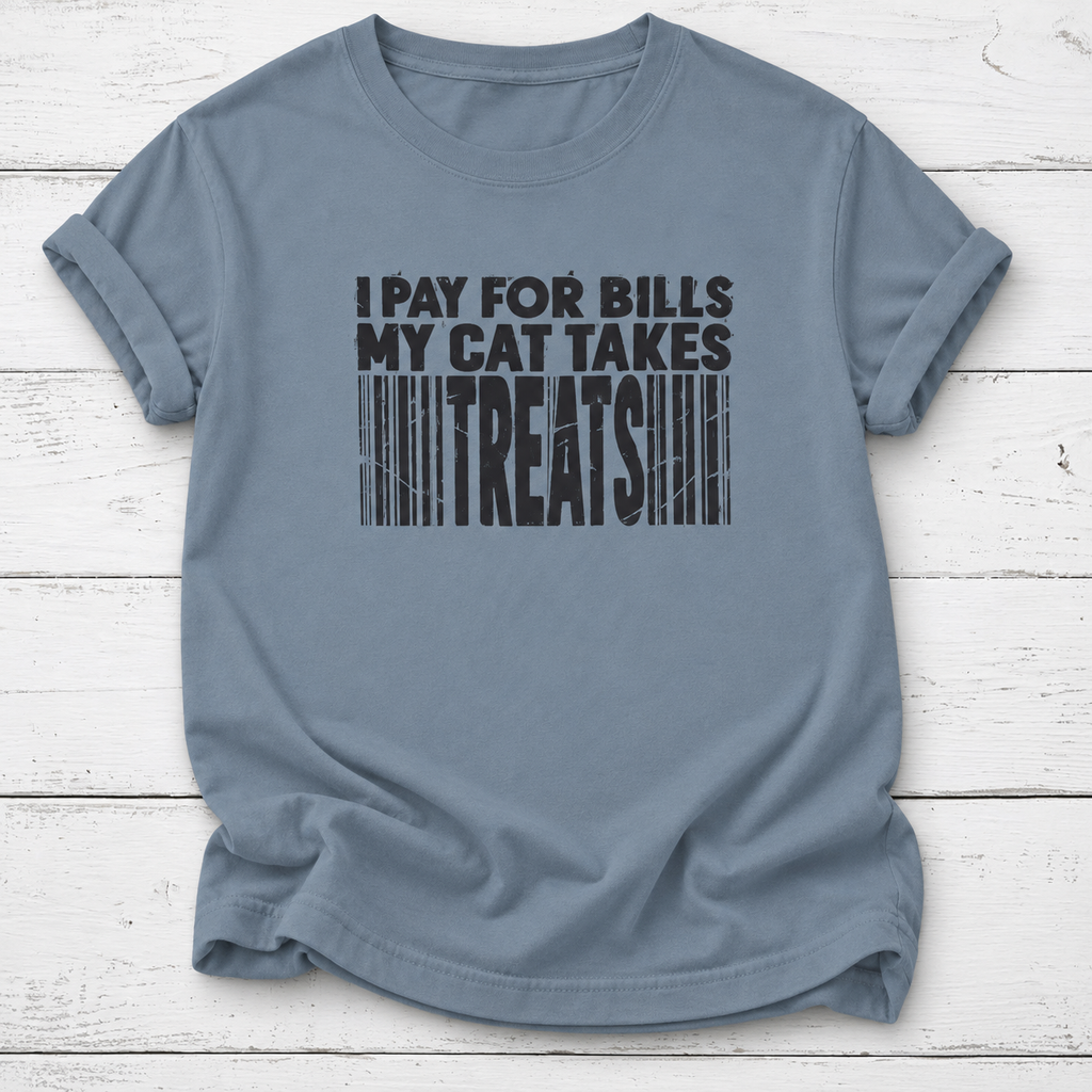 A slate blue crewneck t-shirt with a black graphic print that reads 'I PAY FOR BILLS MY CAT TAKES TREATS' styled like a barcode, laid flat on a white wood plank background.