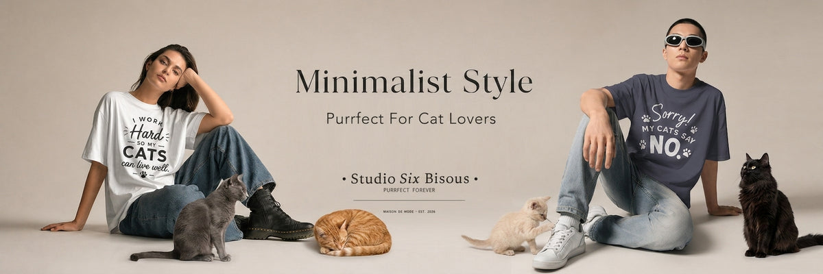 HERO banner for Studio Six Bisous featuring a man and a woman wearing minimalist cat-themed graphic t-shirts, posed with several cats on a light beige studio background. The text reads 'Minimalist Style' and 'Purrfect For Cat Lovers'.