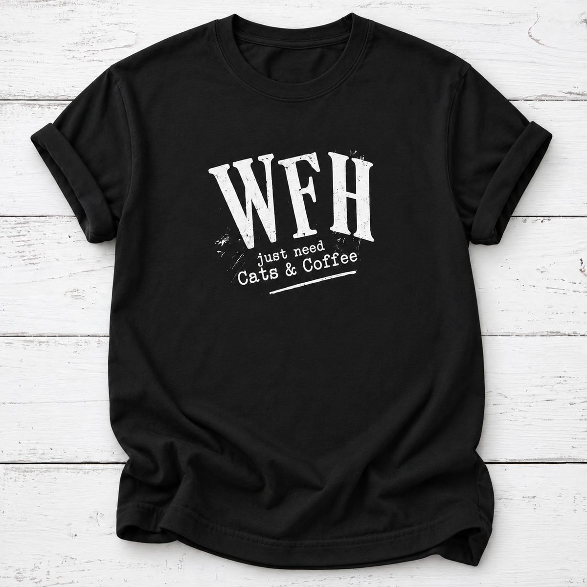 A black short-sleeve crewneck t-shirt with a distressed white graphic print reading 'WFH just need Cats & Coffee', laid flat on a white wood plank background.