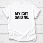 White T-shirt with bold black “My Cat Said No.” lettering and rolled sleeves, laid flat on white wooden boards.